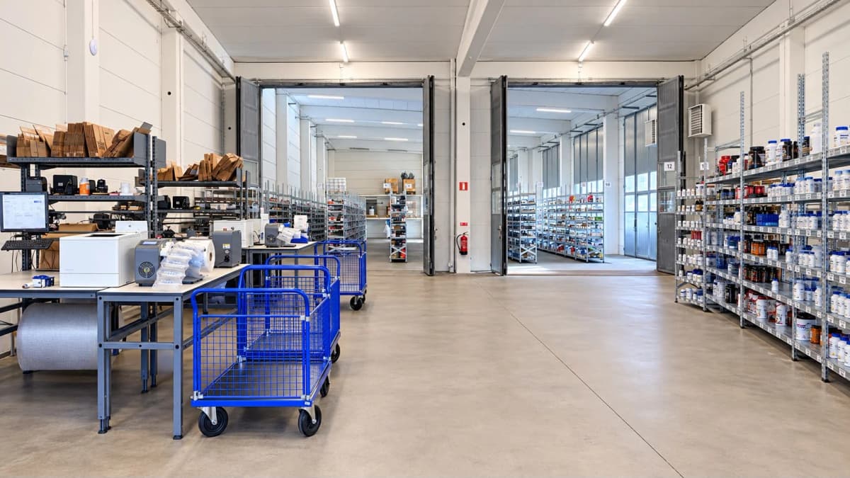 Packing stations, packaging materials and blue picking trolleys in the warehouse